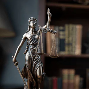 Estátua da Justiça diante de livros jurídicos